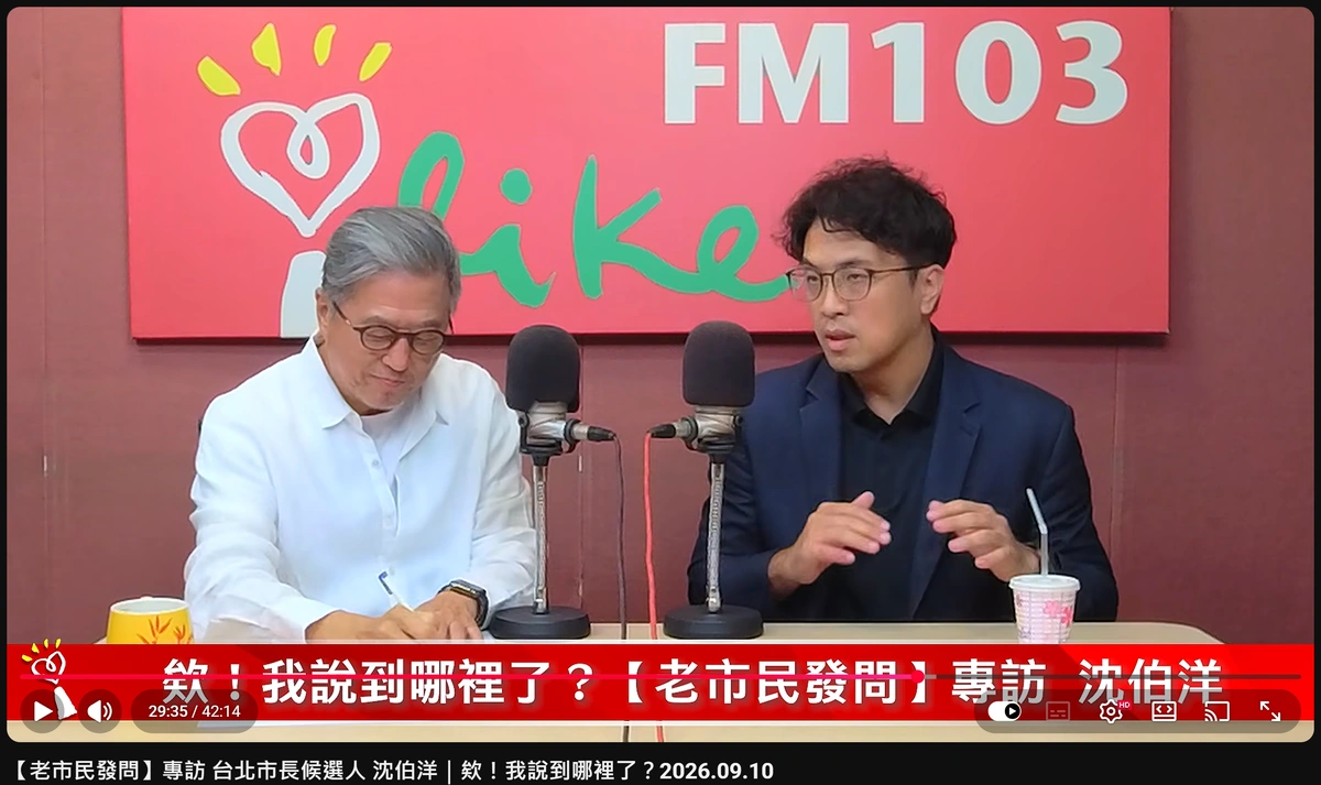 影片 29 分 35 秒處截圖:王偉忠低頭在紙上寫筆記,沈伯洋在一旁說明